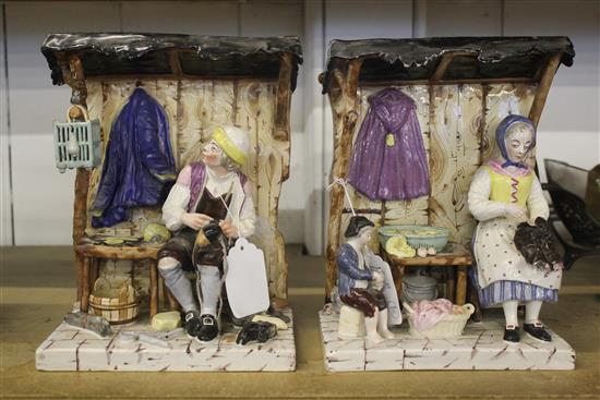A pair of French faience groups of a cobbler and seamstress beneath canopies, 19th century, 23.5cm, one restored